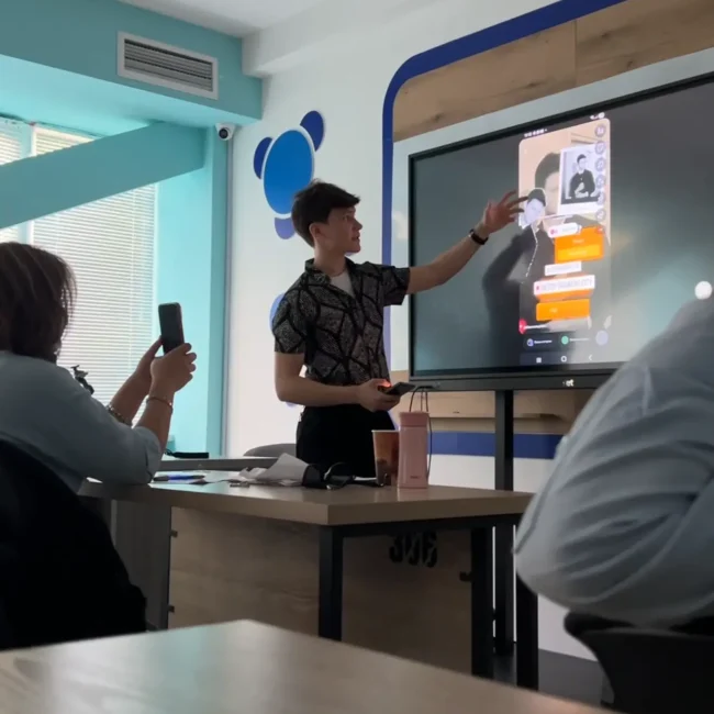 O'qituvchi bolalarga doskada ko'rsatib beryapti.